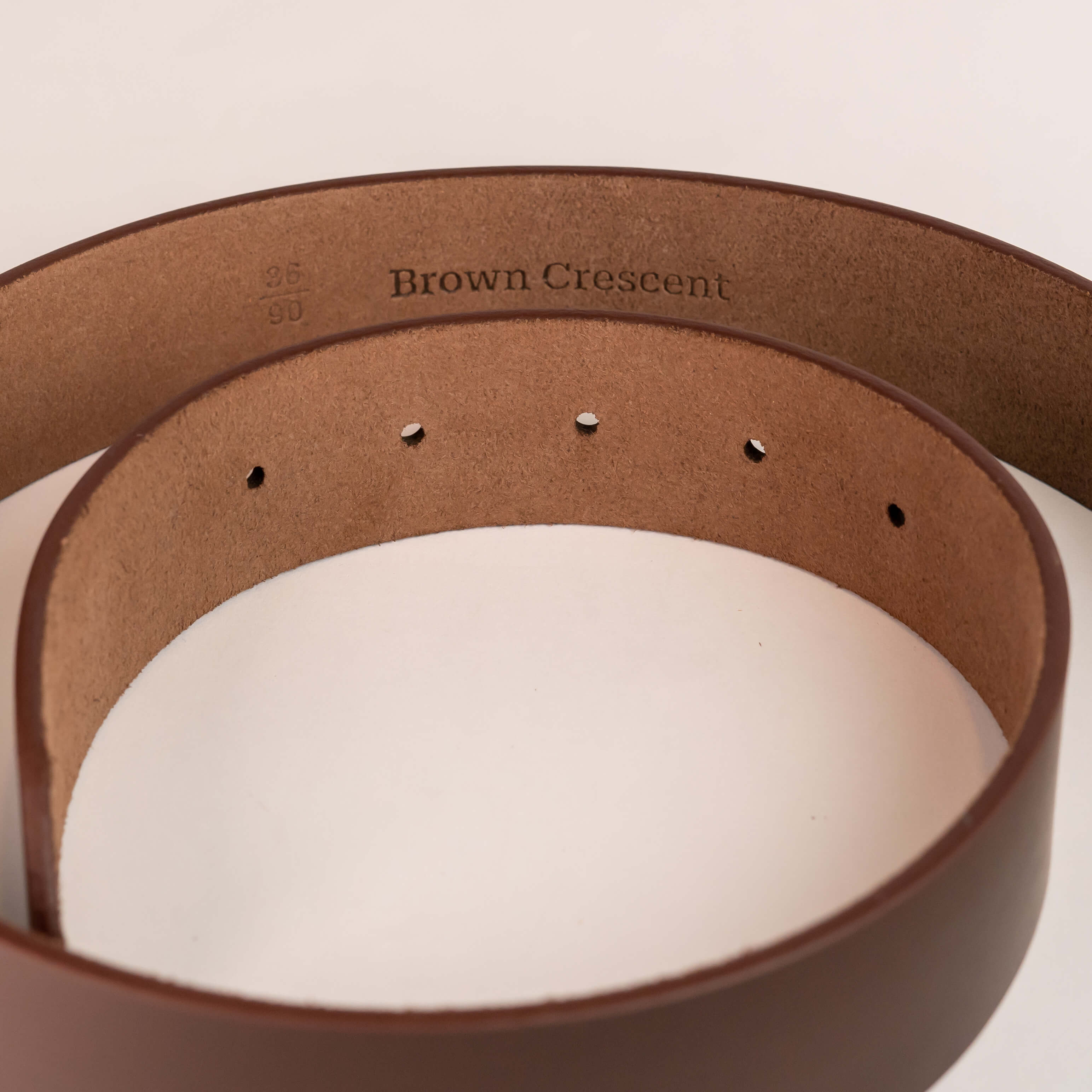 Brown Crescent leather belt interior showing premium branding and craftsmanship details