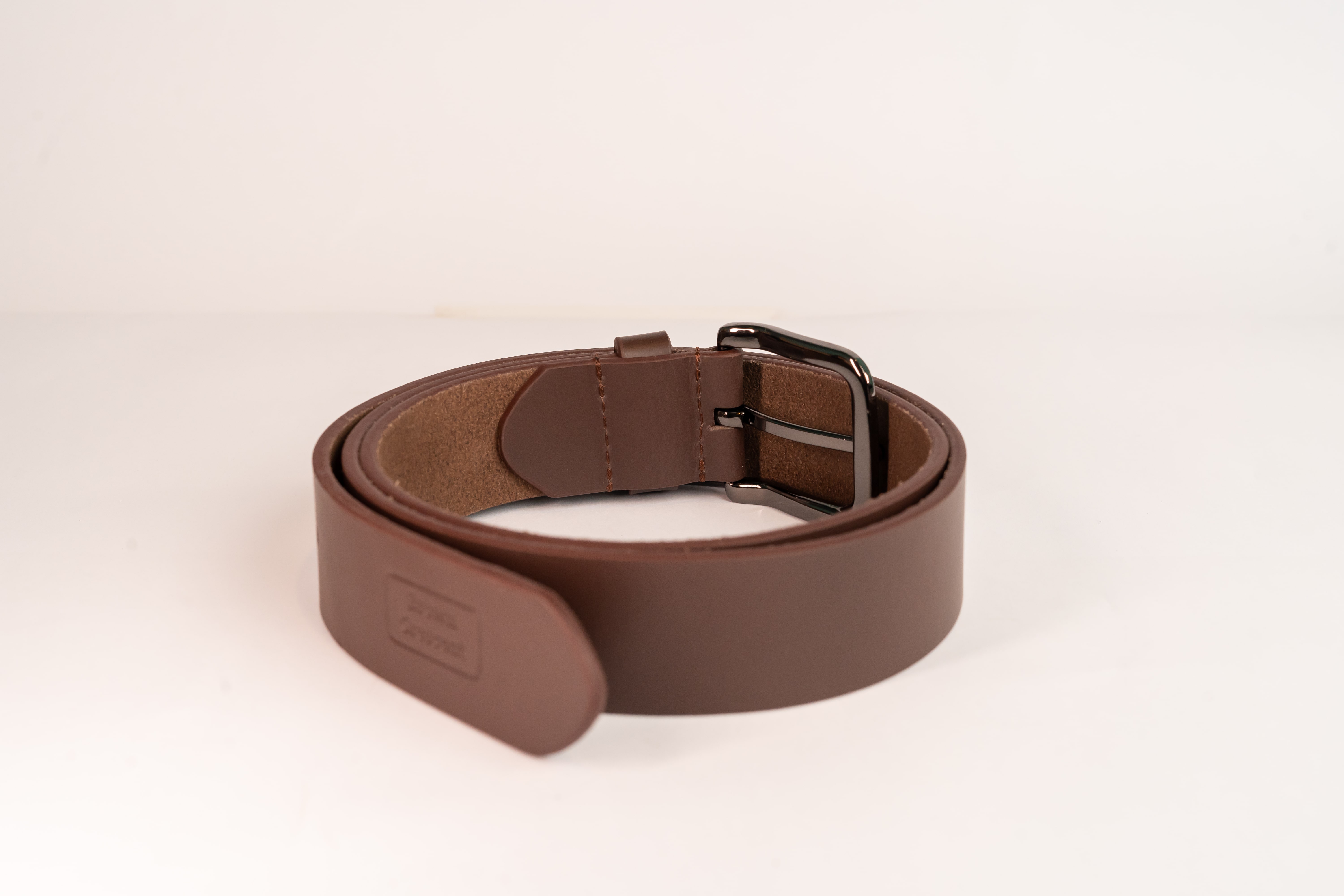 Brown Crescent leather belt highlighting premium hardware and construction details