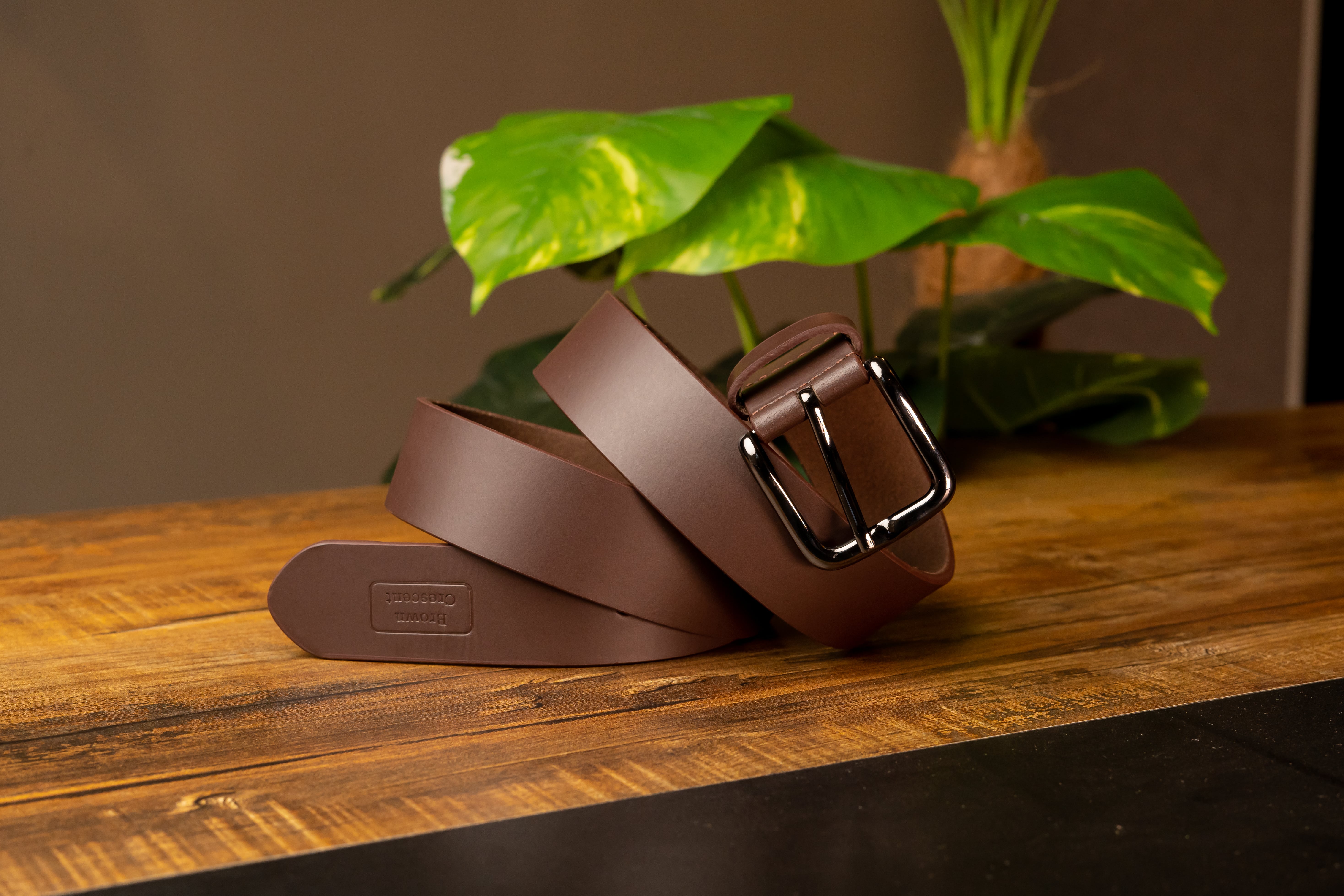 Premium Brown Crescent leather belt showcasing luxury craftsmanship on wooden surface